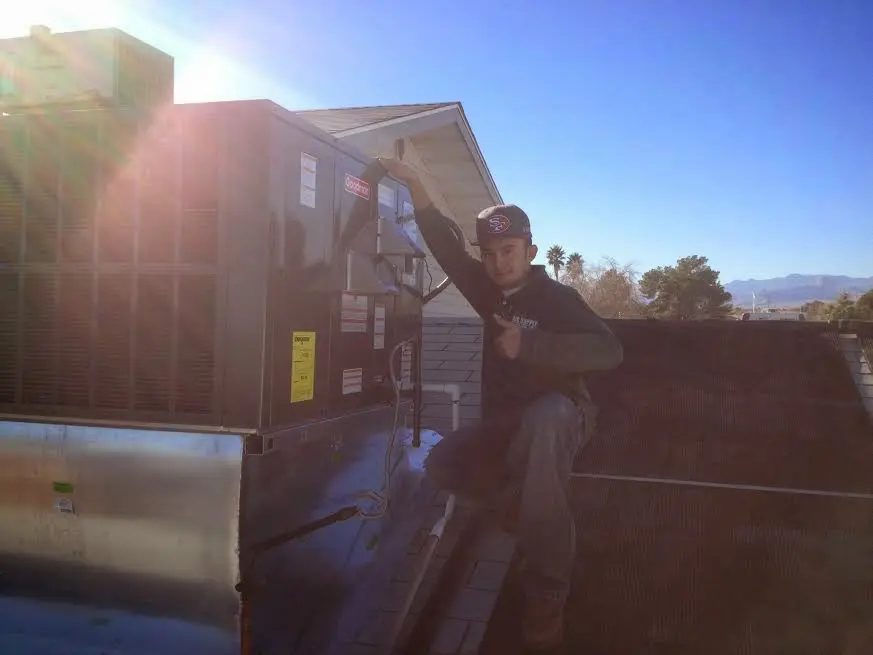 HVAC technician performing Heat Pump Repair on a rooftop unit in Fruita